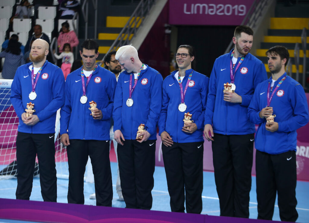 Daryl and his five teammates stand behind the podium with silver medals around their necks during the medal ceremony at the 2019 Parapan American Games in Lima, Peru.