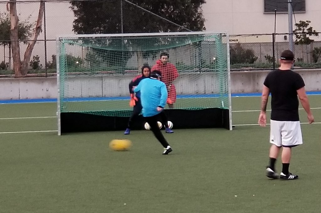 Athlete Alvaro Mora takes a shot on goal as the goalie tries to defend