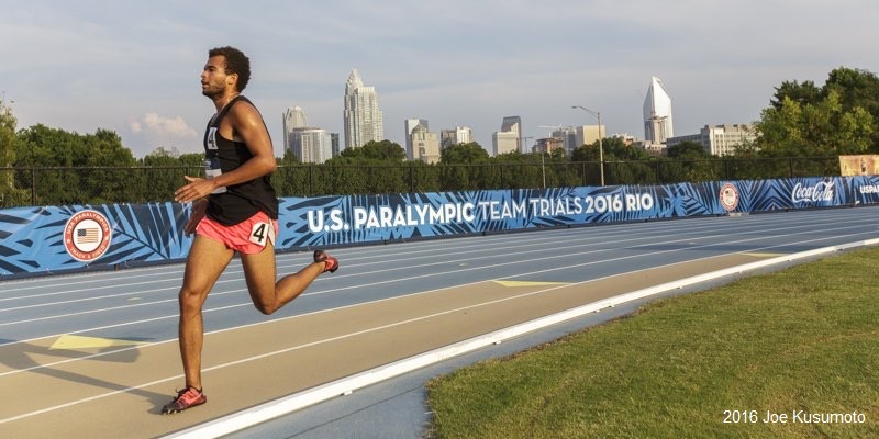 Chaz runs on a blue track with a banner behind him that reads U.S. Paralympic Team Trials 2016 Rio.