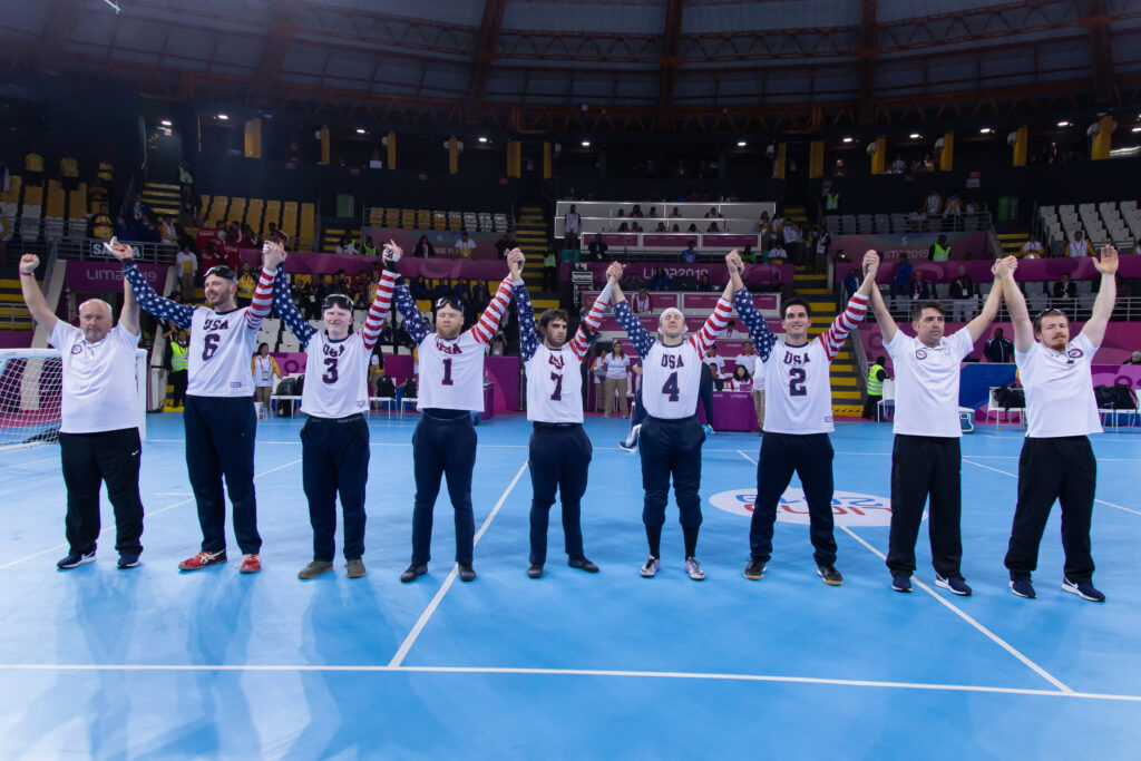 Matt (#7 in middle) raises his arms along with teammates and coaches after the USA Men's Goalball Team clinched a berth in the Tokyo 2020 Paralympic Games at the 2019 Parapan American Games in Lima, Peru.