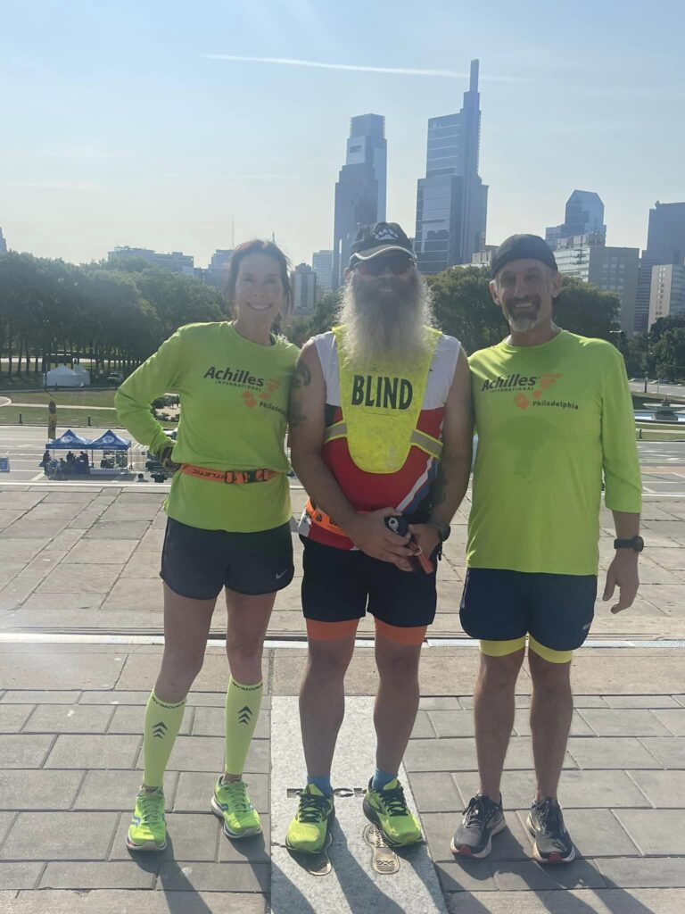 USABA Endurance Sport Ambassador Rob Sanchas poses with his guides on Rocky's footprints in downtown Philadelphia.